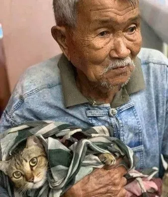 台风来袭泰国南部 老爷爷紧紧抱着爱猫逃难